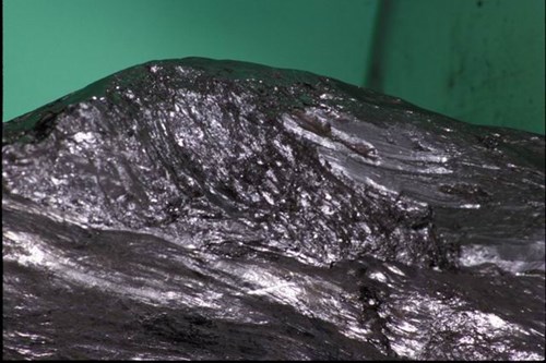 A close up photo of vein graphite shows the acicular structure of adjacent vein graphite crystals.